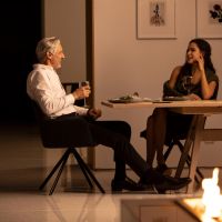 A couple enjoys dinner in a warmly lit dining room.