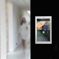 Savant wall-mounted touchscreen shows surveillance footage from a patio’s video doorbell.