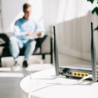 person sitting on a couch with a router sitting on a table in the foreground