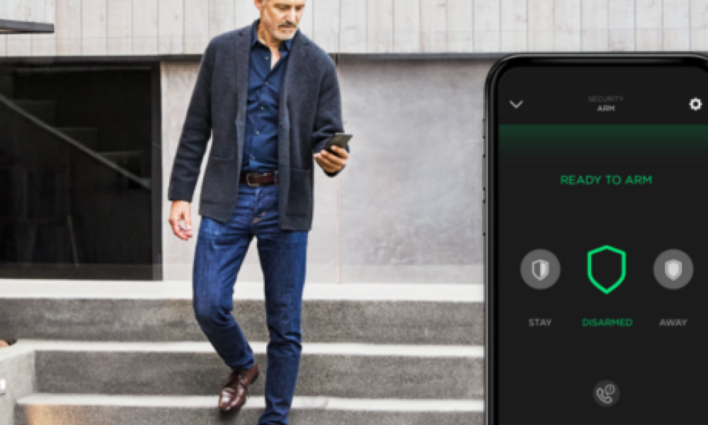 <span class="uk-h4">Man using a smartphone to control his home security system while walking down stone steps.</span>