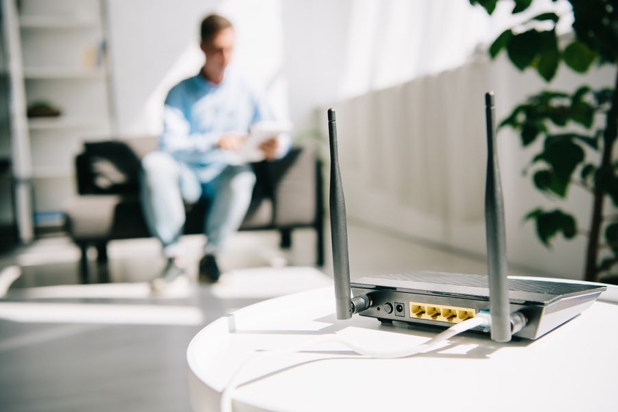 person sitting on a couch with a router sitting on a table in the foreground