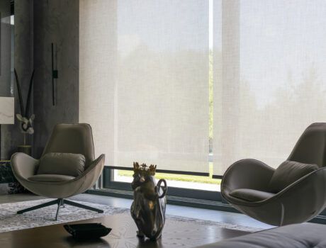 Two chairs in front of two lowered motorized shades.