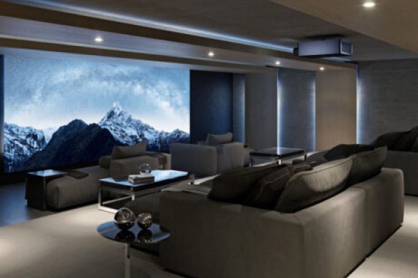 A home theater with chaise lounges, a Sony projector, and a large movie screen.