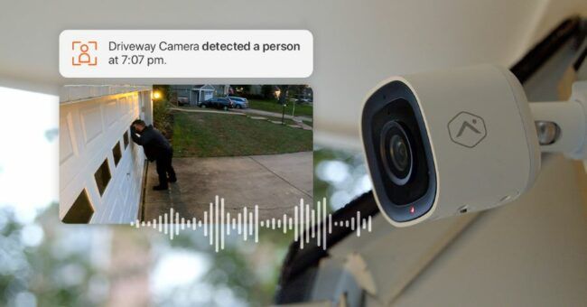 An Alarm.com security camera sending a notification showing a person looking into a garage.