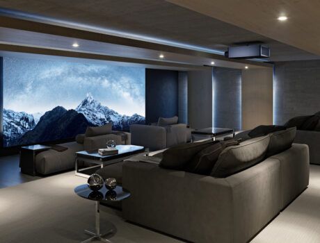 A home theater with chaise lounges, a Sony projector, and a large movie screen.