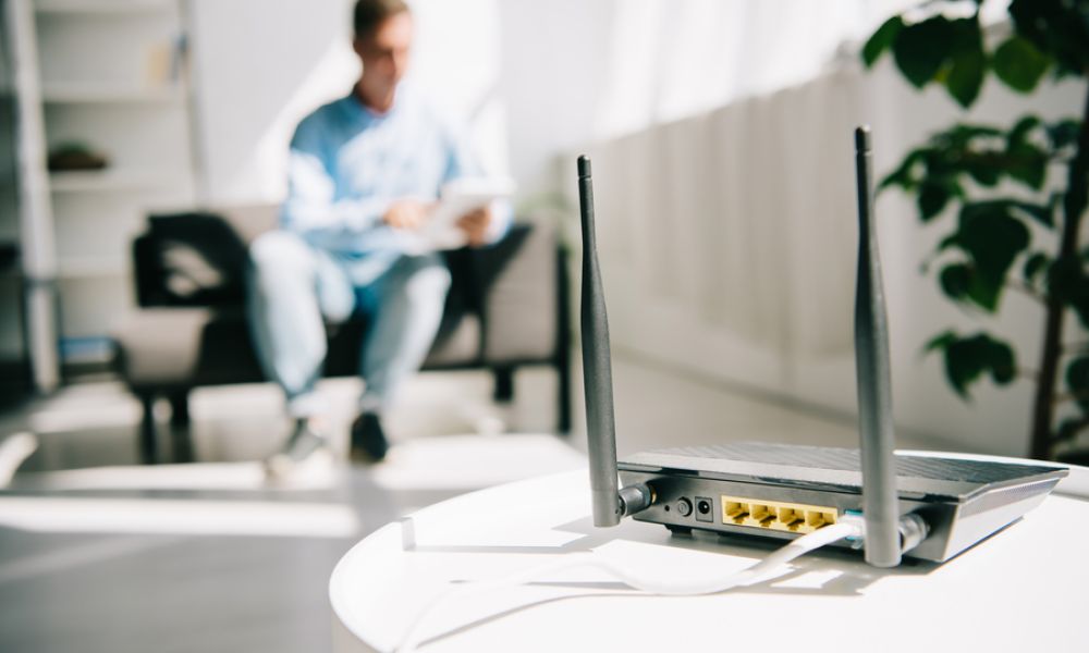 <span class="uk-h4">person sitting on a couch with a router sitting on a table in the foreground</span>