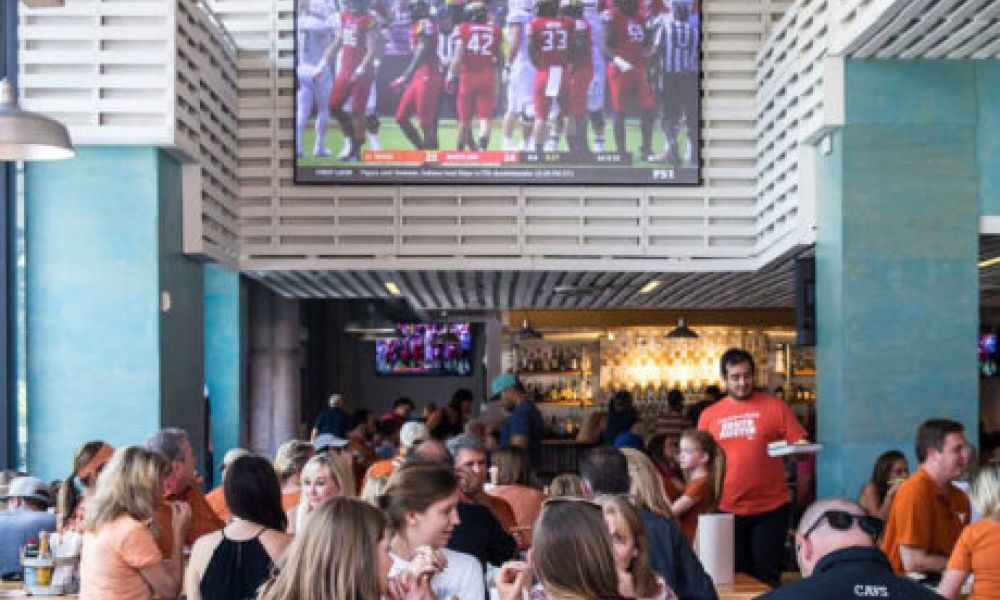 <span class="uk-h4">A busy restaurant with two displays, including a Screen Innovations Zero Edge Pro TV.</span>