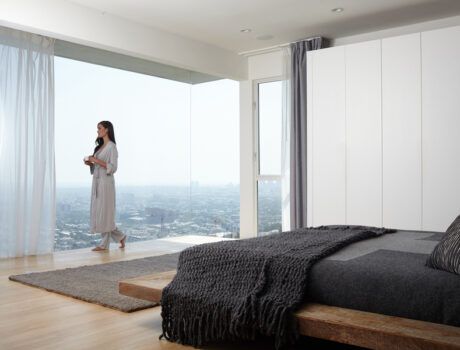 Savant motorized drapes installed on floor-to-ceiling windows overlooking a cityscape