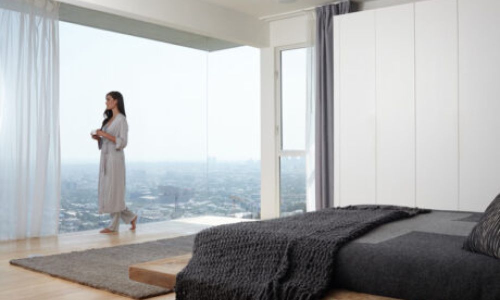 <span class="uk-h4">Savant motorized drapes installed on floor-to-ceiling windows overlooking a cityscape</span>