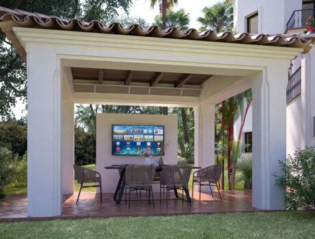 wall-mounted Coastal Source Razor speakers near an outdoor pergola with a TV and chairs underneath